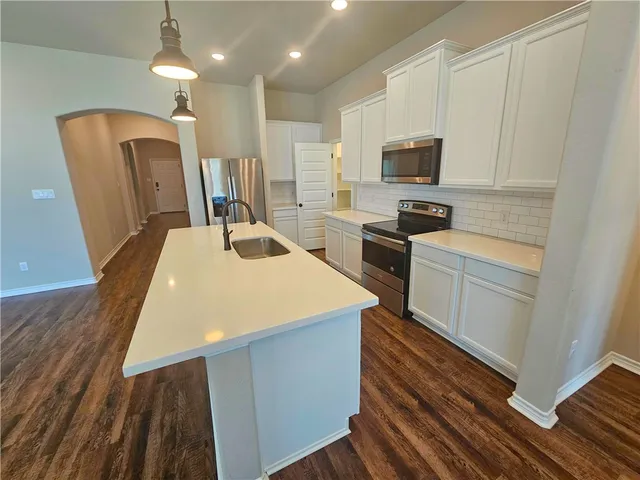 a kitchen with sink a microwave and refrigerator