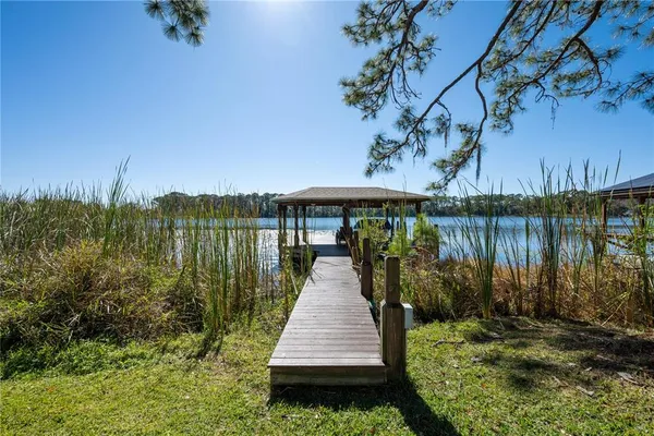 an aerial view of a house with a yard and lake view