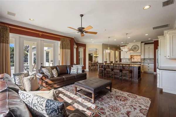 a kitchen with stainless steel appliances kitchen island granite countertop a dining table chairs and white cabinets