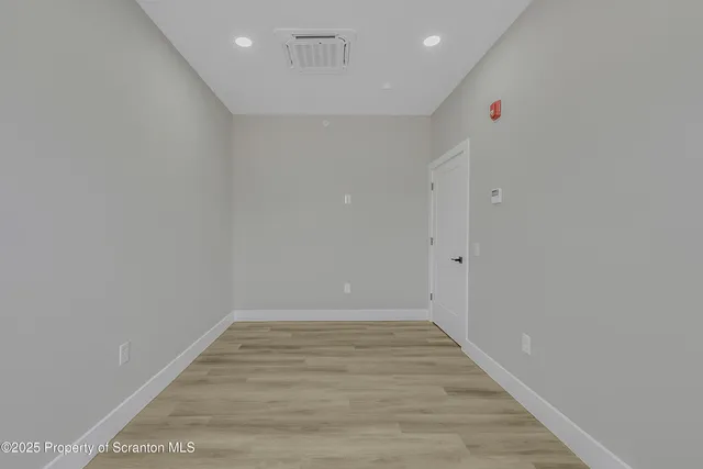 a view of an empty room with wooden floor