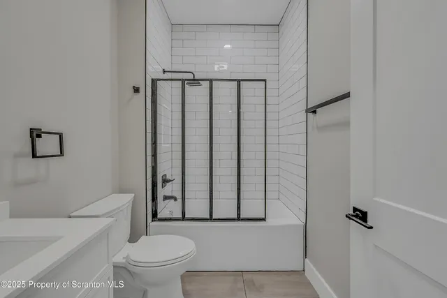 a bathroom with a toilet and a shower