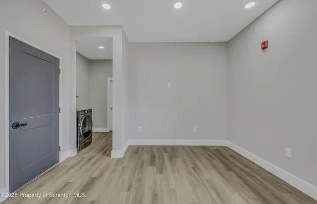 a view of a room with wooden floor and a hallway