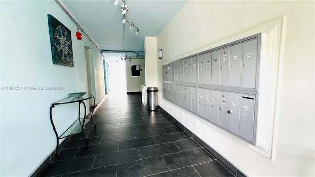 a hallway with wooden floor a chandelier and entryway