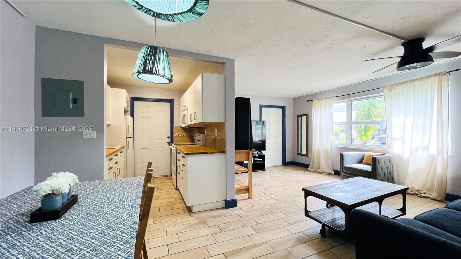 801 Meridian Avenue, Unit 1A Miami Beach, FL 33139 - Photo 5 of 18 a living room with furniture and a chandelier