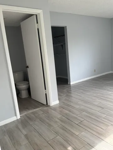 an empty room with wooden floor and stairs