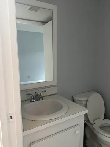 a bathroom with a sink toilet and mirror