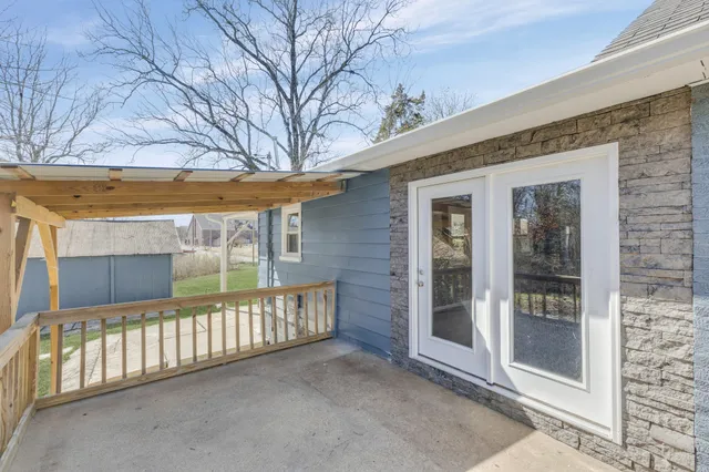 a view of a porch with a floor to ceiling window and wooden fence