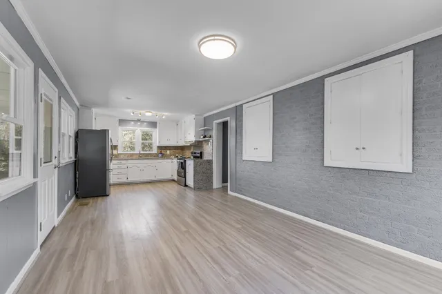 a view of kitchen with wooden floor electronic appliances and window