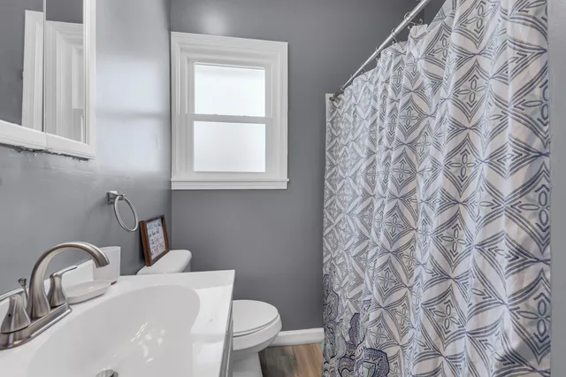 a bathroom with a toilet sink and mirror