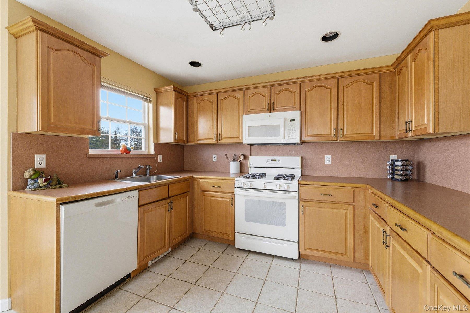 23 Goose Neck Lane Riverhead, NY 11901 - Photo 10 of 28 a kitchen with a stove a sink and a refrigerator