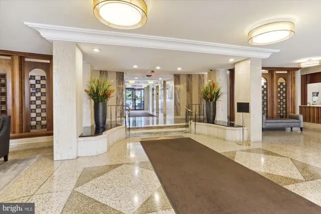 a view of a hallway with furniture and a bathroom