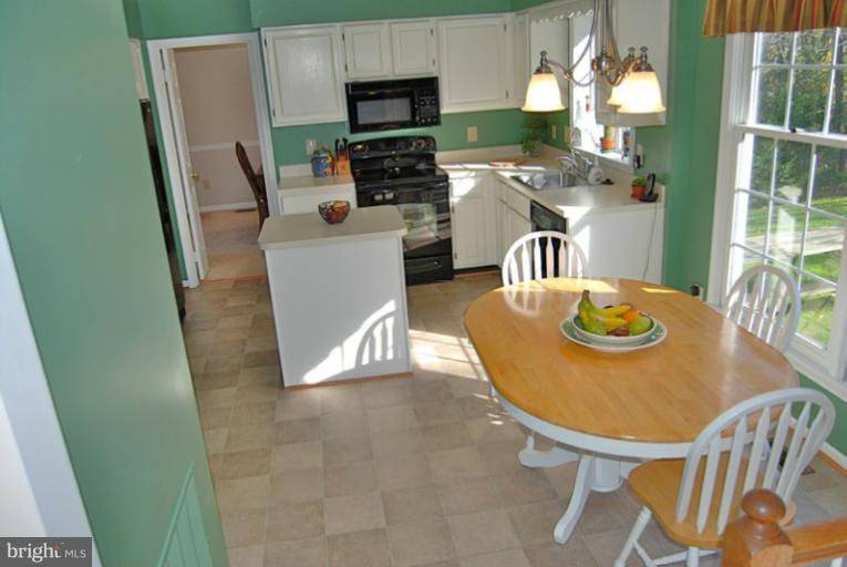 a kitchen with stainless steel appliances a microwave a dining table and chairs