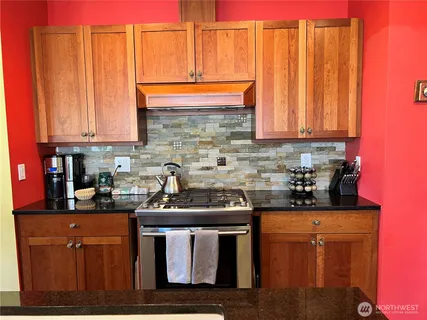 a kitchen with stainless steel appliances granite countertop a stove a sink dishwasher and a microwave