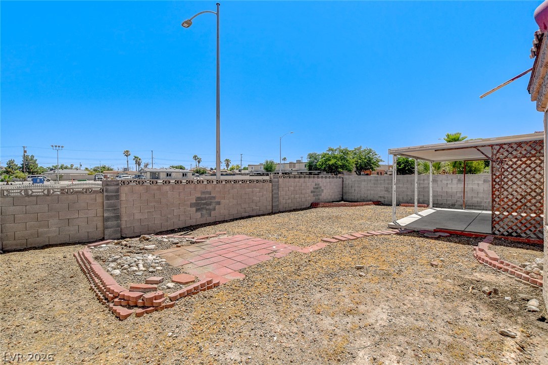 6209 Warm River Road Las Vegas, NV 89108 - Photo 39 of 39 A spacious backyard with block wall fencing and a covered patio for outdoor enjoyment.