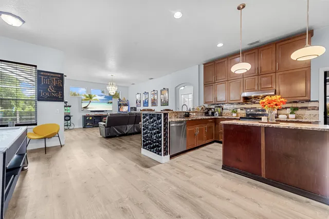 a living room with furniture kitchen and a wooden floor