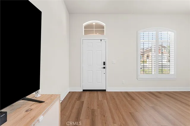 a view of a bedroom with wooden floor and window