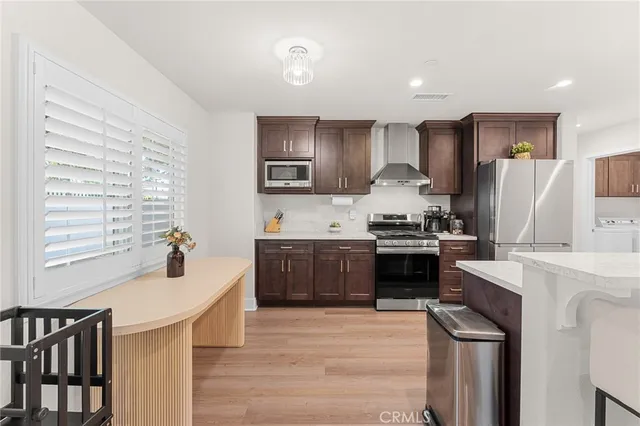 a kitchen with stainless steel appliances kitchen island granite countertop a stove a sink dishwasher and a refrigerator