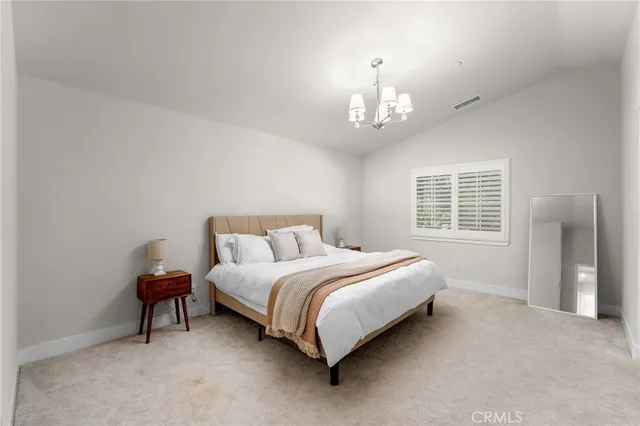 a spacious bedroom with a bed and a chandelier