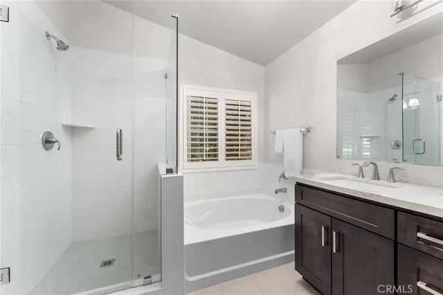 a bathroom with a tub sink shower and a mirror