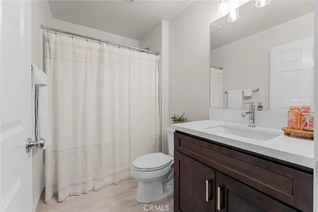 a bathroom with a sink a toilet a mirror and shower curtain