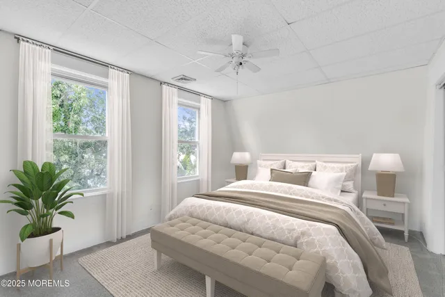 a bedroom with a large bed and a potted plant