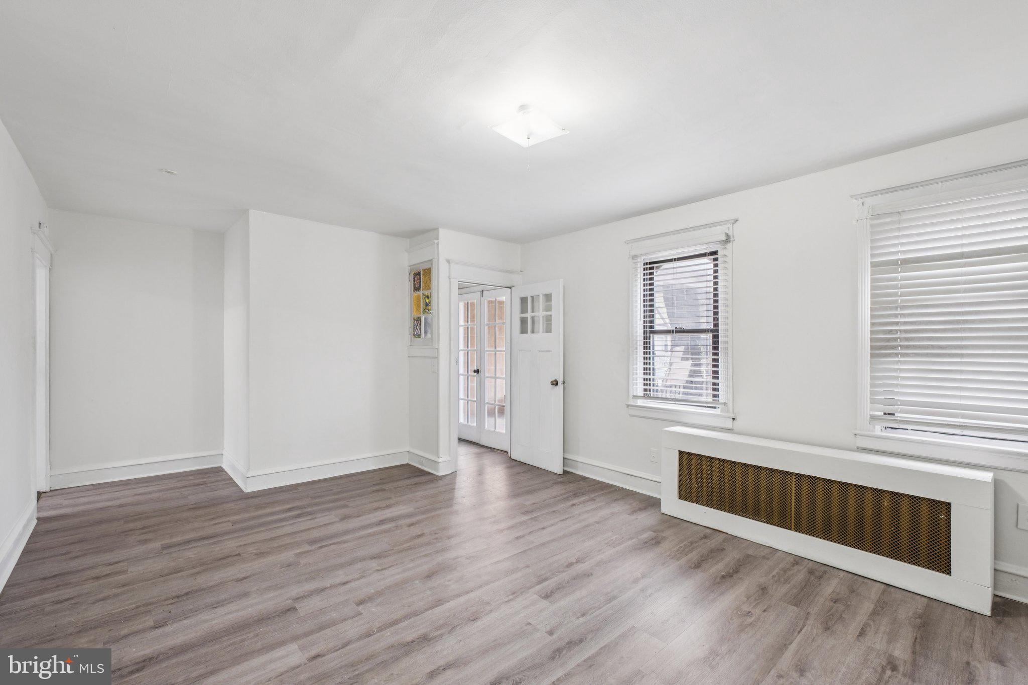 235 Ashby Road Upper Darby, PA 19082 - Photo 5 of 30 a view of an empty room with wooden floor and a window
