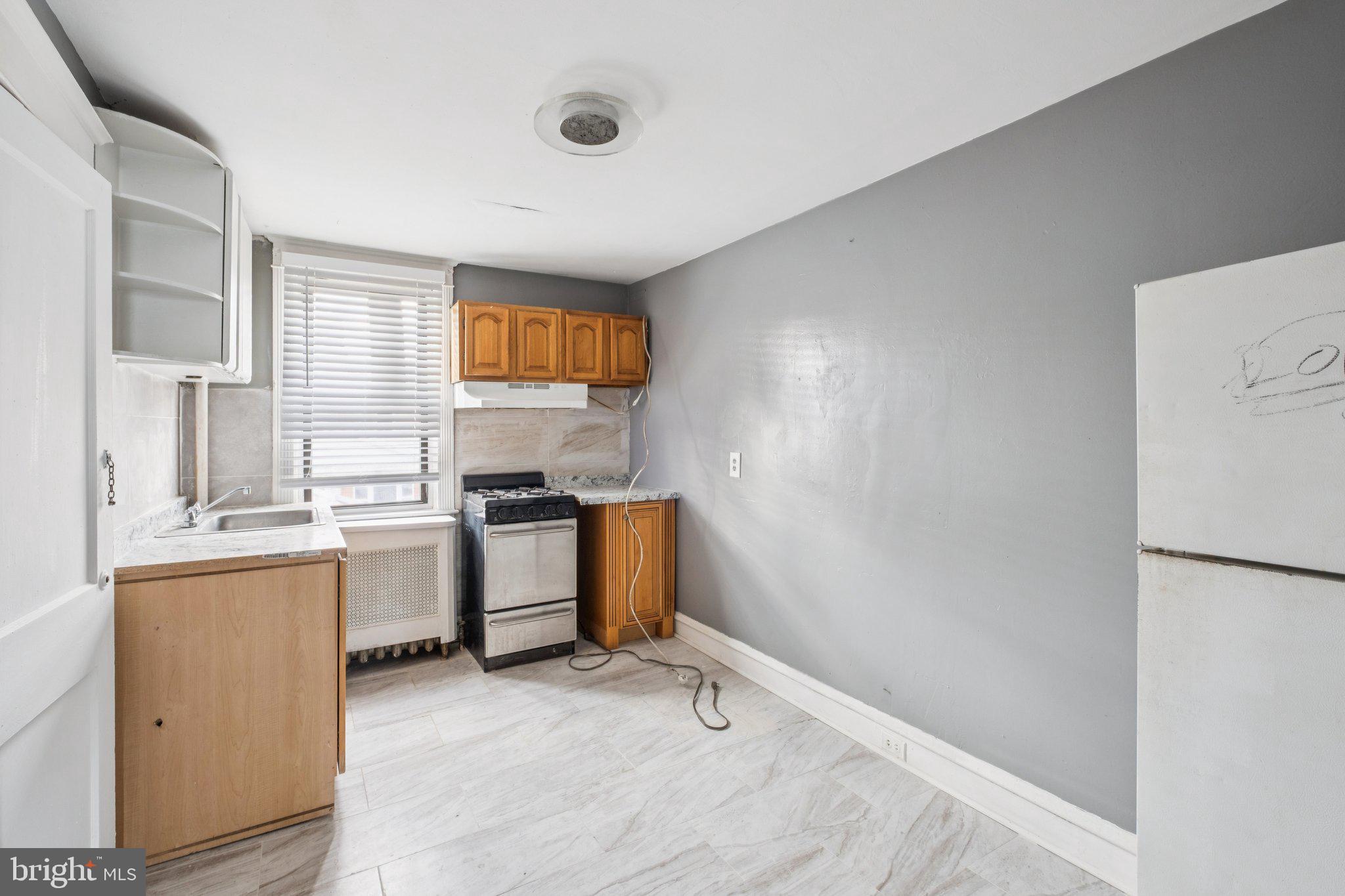 235 Ashby Road Upper Darby, PA 19082 - Photo 9 of 30 a kitchen with a refrigerator and a stove top oven