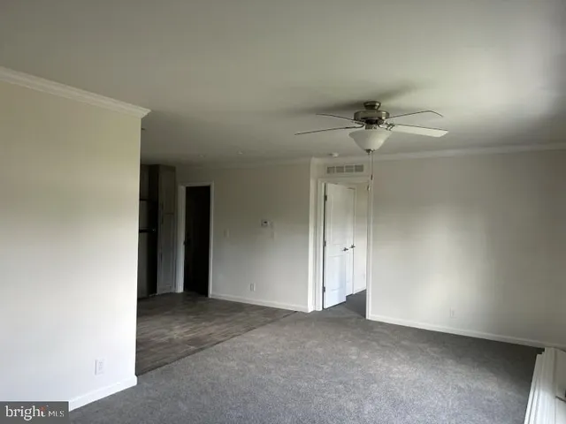 an empty room with a ceiling fan and a window