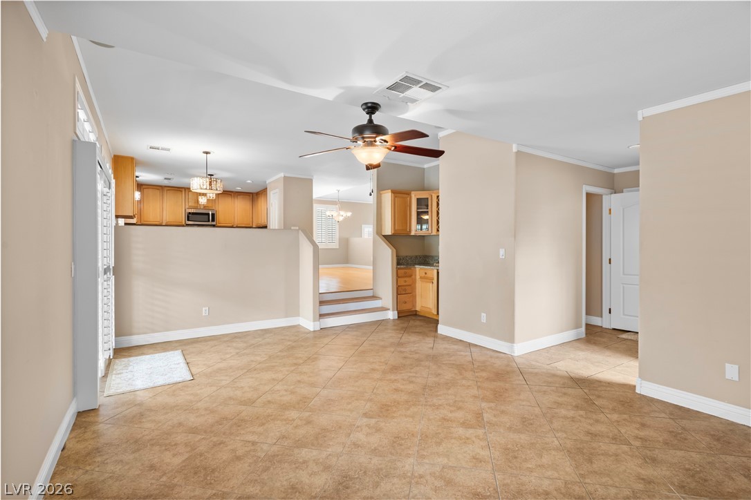 708 Vortex Avenue Henderson, NV 89002 - Photo 19 of 71 A split-level layout with warm tile flooring connects a well-appointed kitchen and living areas, offering functional flow.