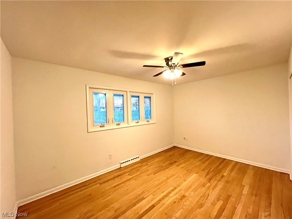 7687 Ragall Parkway Cleveland, OH 44130 - Photo 28 of 37 Unfurnished room featuring baseboard heating, light hardwood / wood-style floors, and ceiling fan