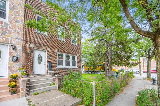 a front view of a house with a garden and trees