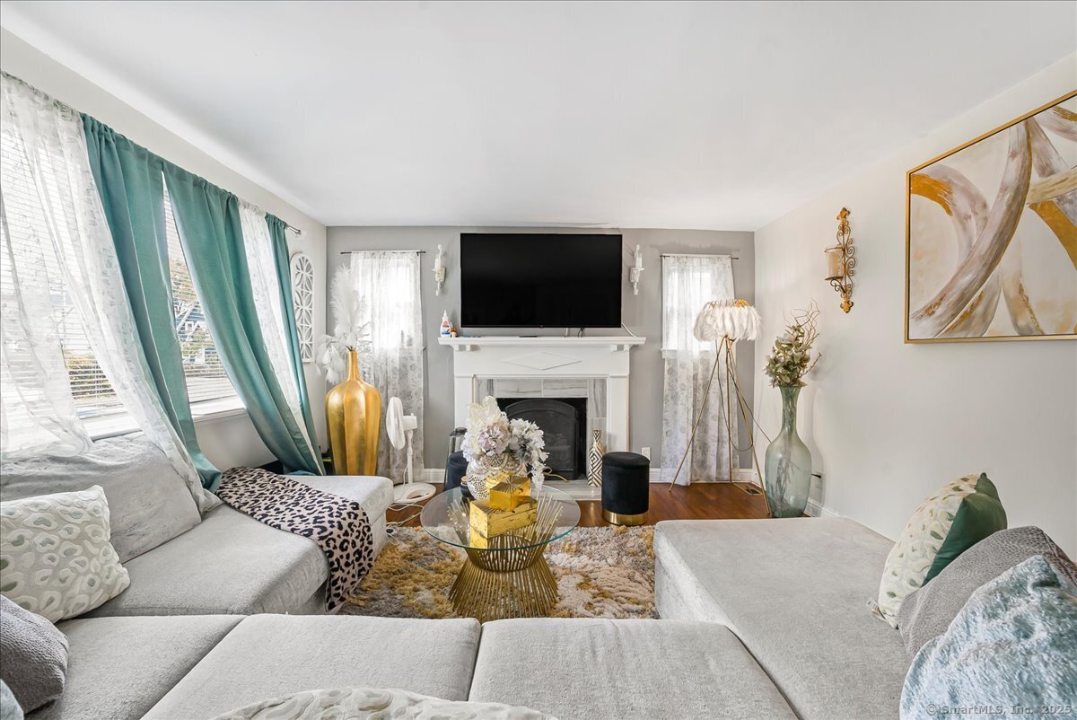 631 Fairview Avenue Bridgeport, CT 06606 - Photo 16 of 22 a living room with furniture a fireplace and a flat screen tv