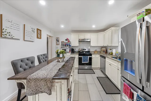 a kitchen with stainless steel appliances granite countertop a refrigerator sink and stove