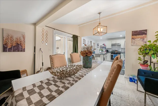 a living room with furniture a dining table and paintings on the wall