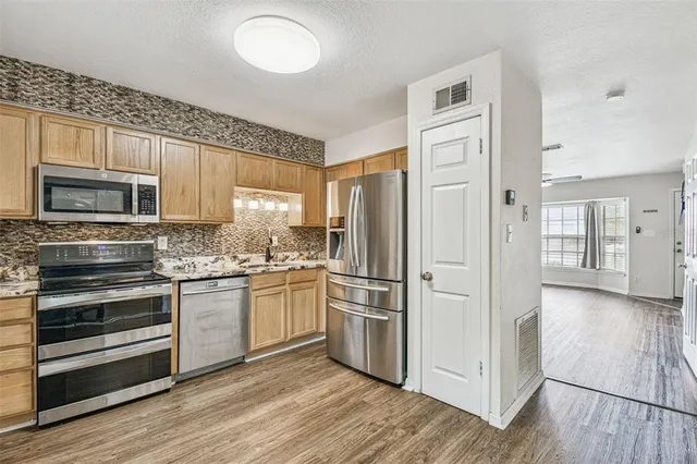 a kitchen with stainless steel appliances granite countertop a refrigerator stove and sink
