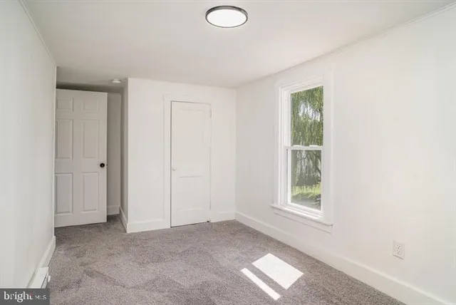 an empty room with windows and closet