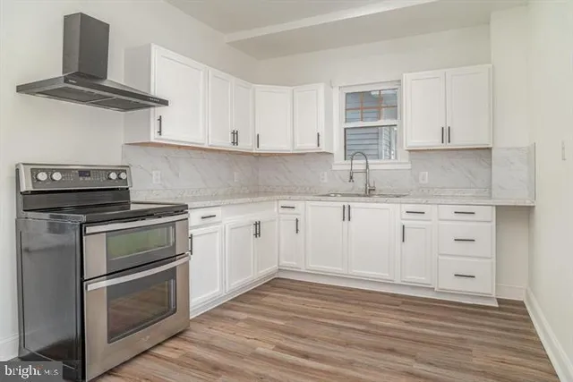a kitchen with cabinets appliances and a wooden floor