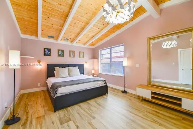 a spacious bedroom with a bed and a chandelier