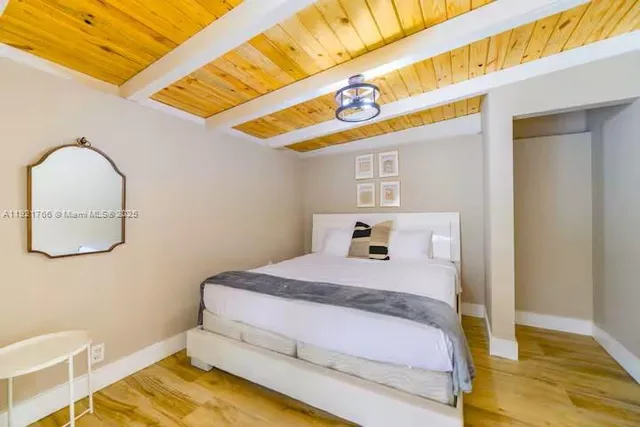 a bedroom with a bed and a wooden floor