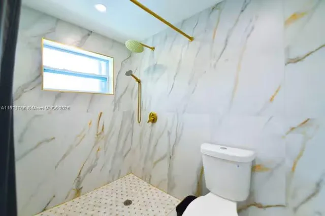 a white toilet sitting next to a bathroom sink and a shower