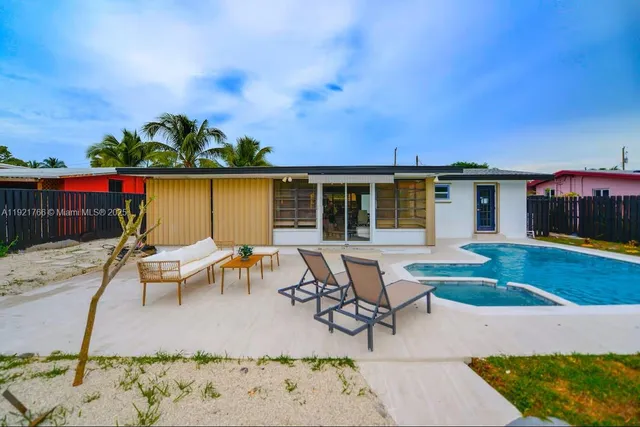 a view of a patio with table and chairs with wooden fence