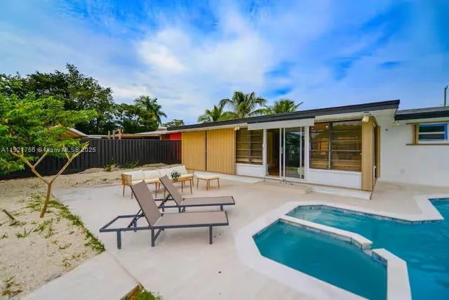 front view of a house with a chairs and table in a patio