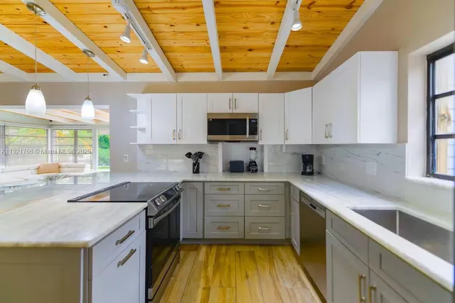 a kitchen with stainless steel appliances granite countertop a sink a stove and cabinets