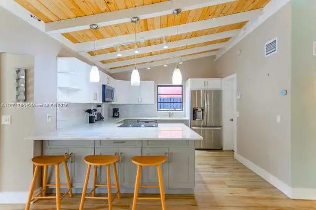 a kitchen with kitchen island stainless steel appliances a sink and cabinets