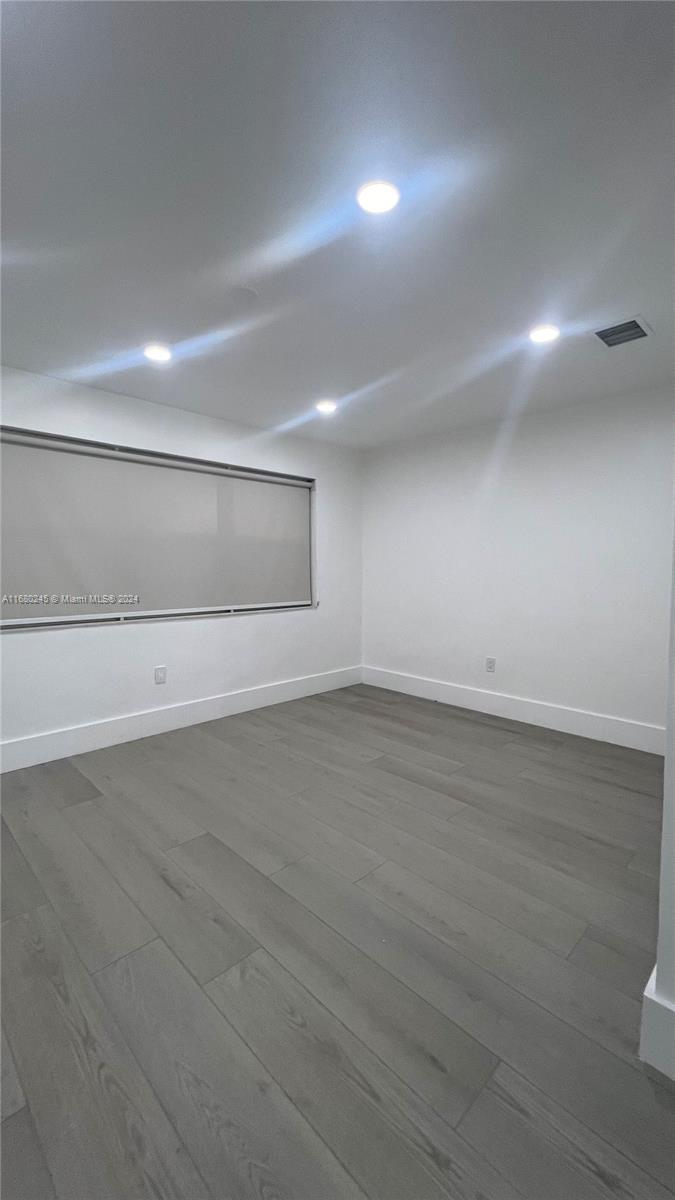 12 Northeast 49th Street, Unit 12 Miami, FL 33137 - Photo 11 of 13 an empty room with wooden floor and windows