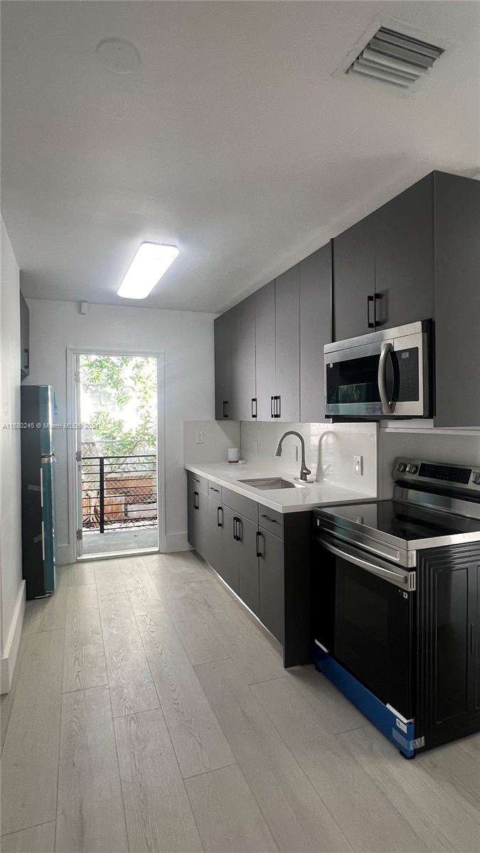 12 Northeast 49th Street, Unit 12 Miami, FL 33137 - Photo 3 of 13 a large kitchen with stainless steel appliances granite countertop a stove a sink and a refrigerator