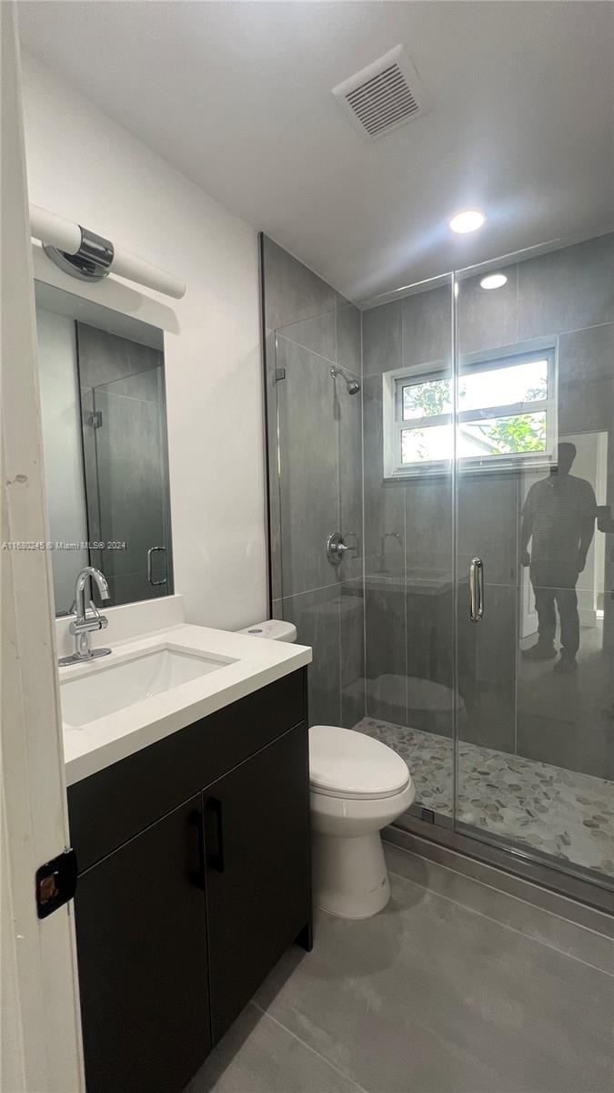 12 Northeast 49th Street, Unit 12 Miami, FL 33137 - Photo 6 of 13 a bathroom with a sink toilet a mirror and shower
