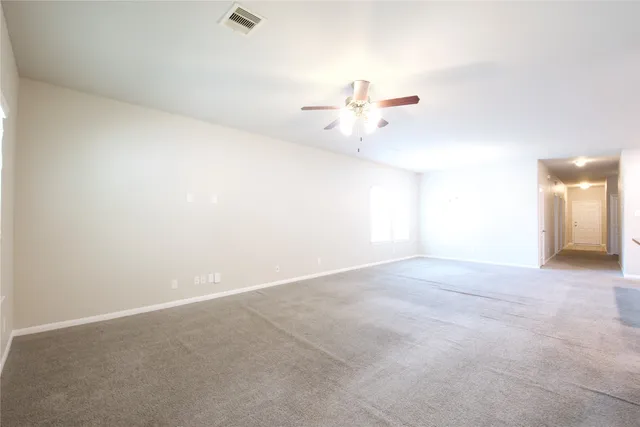 a view of an empty room with a chandelier fan