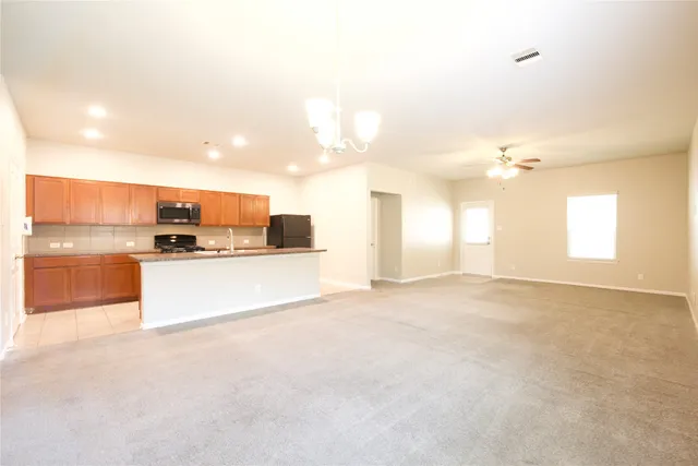 a view of kitchen with kitchen island and stainless steel appliances