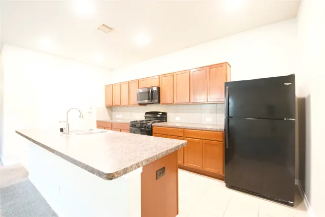 a kitchen with stainless steel appliances granite countertop a refrigerator a stove a sink and a refrigerator